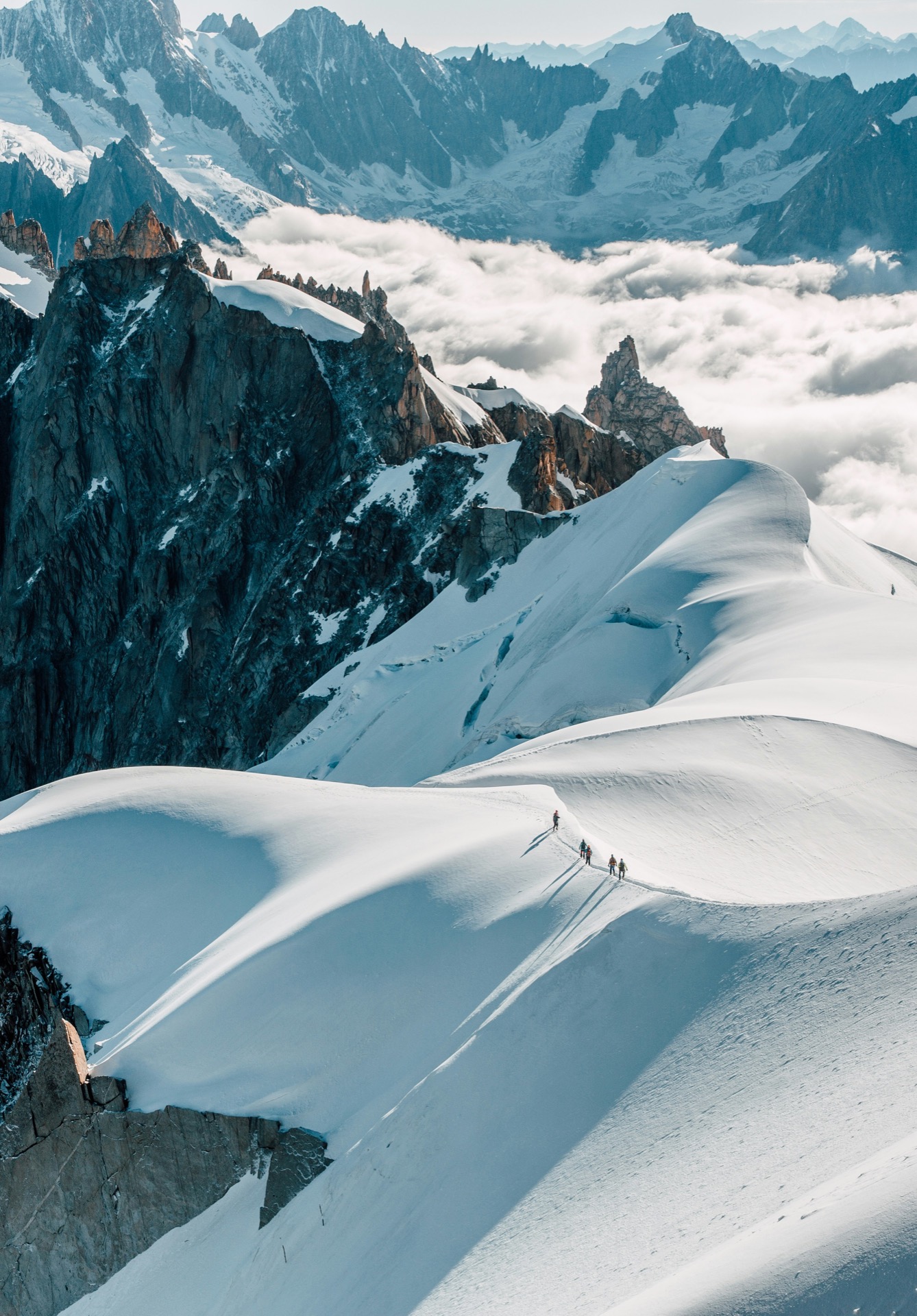 A rope team crossing a snow ridge at altitude — preparation long before the moment